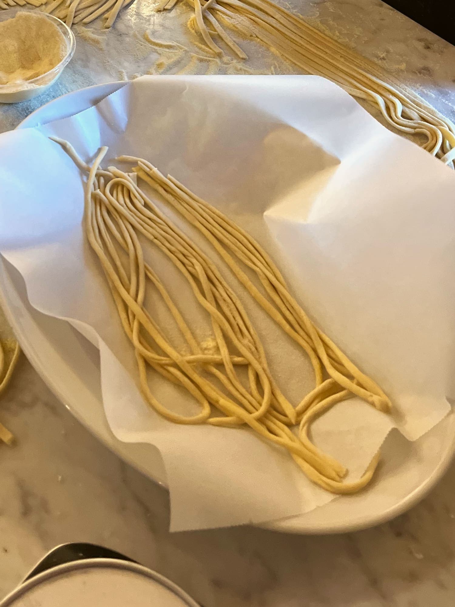 Fresh pasta resting on a marble worktop, cut and waiting to be cooked.