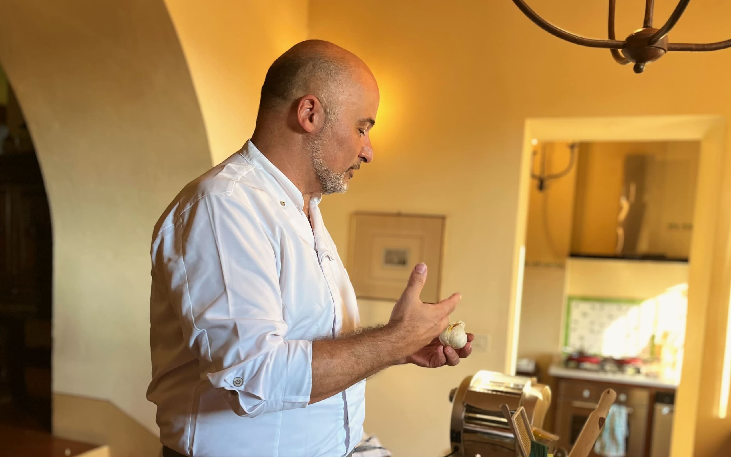 Roberto at work in the vaulted kitchen of a Tuscan villa, with the pasta machine on the worktop.